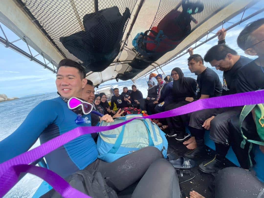 Snorkelers in wetsuits on board heading to the reef